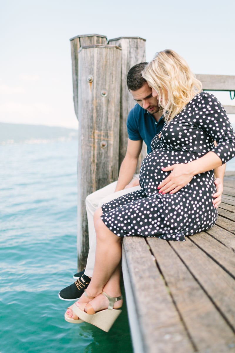 photo de grossesse à Annecy du couple assis sur le ponton